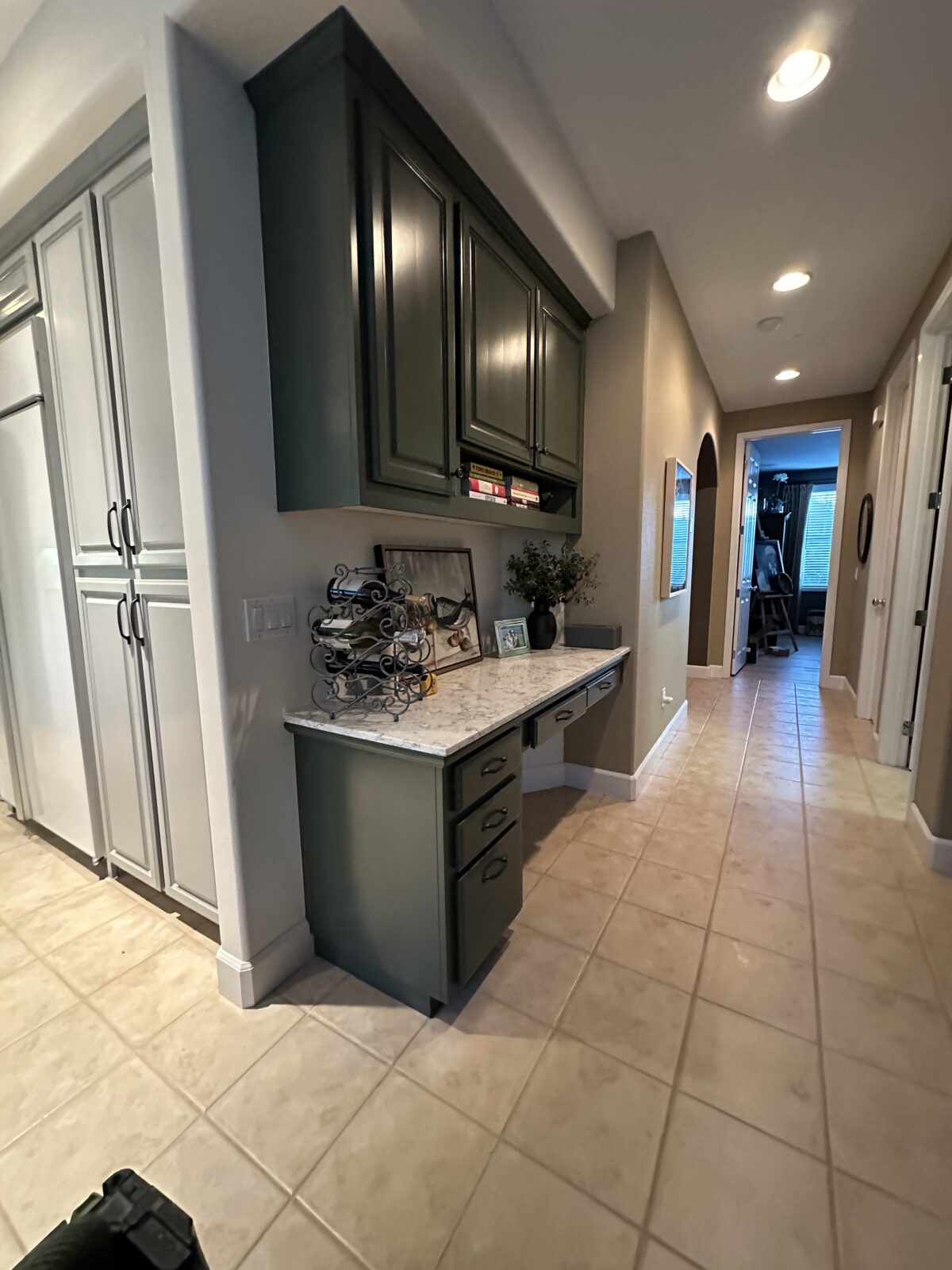 Dark green painted upper cabinets over a built-in desk