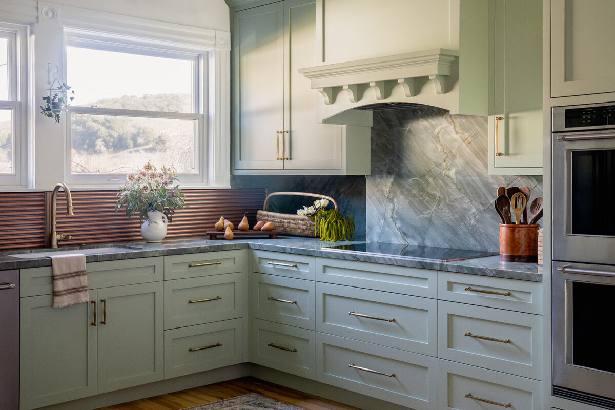 Kitchen with sage green painted cabinets and brass hardware