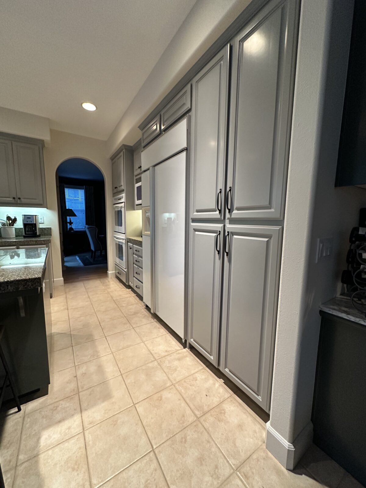 Gray painted kitchen cabinets and tall pantry doors